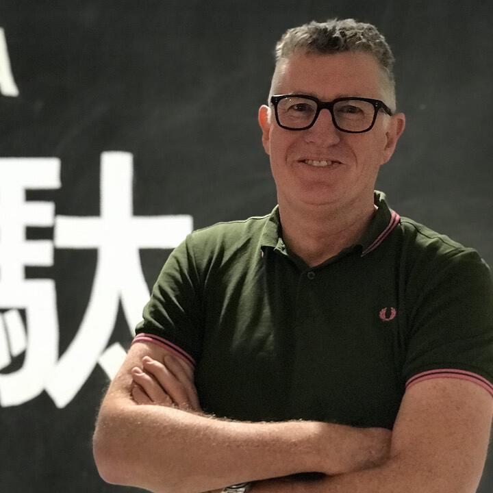 Nigel Dalton standing in front of Japanese characters for muda or waste Nigel Dalton Thoughtworks social scientist lean agile