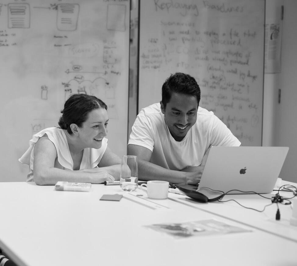 Two Thoughtworkers chatting across a laptop
