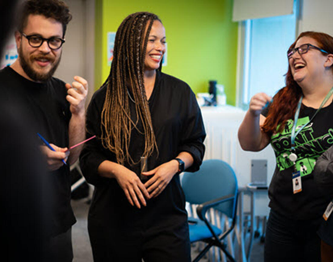 Two of our consultants in Australia, one wearing white, one wearing black. Sitting at a laptop pairing on a client project, both smiling broadly. Perhaps slightly embarrassed that we have caught them on camera!